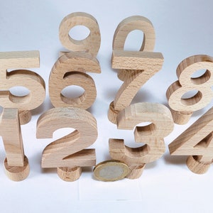 Könnte beinhalten: Holzbaufellzahlen von 1 bis 9, in natürlicher Holzfarbe lackiert. Die Blöcke sind in einem Halbkreis angeordnet, wobei die Zahlen 1, 2, 3, 4, 5, 6, 7, 8 und 9 sichtbar sind.