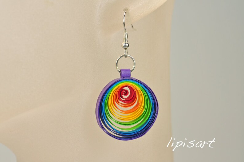 May include: Rainbow colored paper quilled earrings with a purple backing and silver hooks.