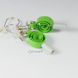 May include: A pair of green paper earrings with a white backing. The earrings are in the shape of a spiral.