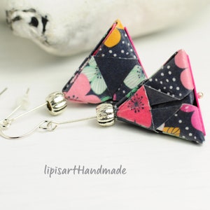 Könnte beinhalten: Ein Paar Origami-Ohrringe mit geometrischer Dreiecksform. Die Ohrringe sind aus buntem gemustertem Papier gefertigt und haben silberne Haken und Perlen.