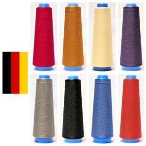 Könnte beinhalten: Acht Garnrollen in verschiedenen Farben, darunter Rot, Orange, Gelb, Lila, Grau, Schwarz, Blau und Rot. Die Rollen sind alle gleich groß und haben die gleiche Form und sind in zwei Reihen zu je vier angeordnet.