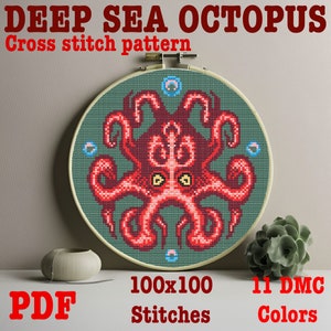 May include: Cross stitch pattern of a deep sea octopus with 11 colors and 100x100 stitches. The octopus is red with yellow eyes and is surrounded by blue bubbles. The pattern is in a hoop and the text "PDF" is in red letters.