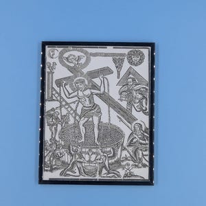 May include: Black and white framed print depicting a religious scene. The central figure carries a cross, surrounded by other figures and symbols. The artwork is detailed and appears to be an illustration or engraving.