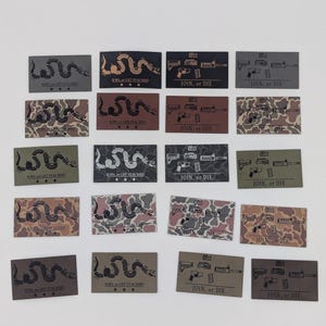 May include: A collection of rectangular patches with various designs and text. Some patches feature a coiled snake with the text "JOIN, or GET STACKED" and stars. Other patches display firearms with the text "JOIN, or DIE."