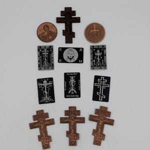 May include: A collection of religious items including three copper-colored Orthodox crosses, two copper-colored circular medallions with embossed imagery, and five rectangular black plaques featuring white printed Orthodox crosses and text.