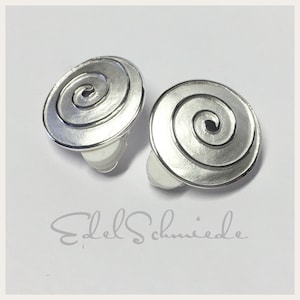 Könnte beinhalten: Ein Paar silberne Ohrringe mit einem Spiraldesign. Die Ohrringe sind im Clip-On-Stil.