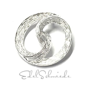 Könnte beinhalten: Silberring mit texturierter Oberfläche, mit zwei ineinander verschlungenen Kreisen. Der Ring ist ein schlichtes und elegantes Design.