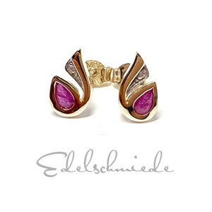 Könnte beinhalten: Ein Paar goldene Ohrringe mit einem rosafarbenen Stein, der in einem einzigartigen, abstrakten Design gefasst ist.