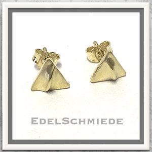 Könnte beinhalten: Ein Paar goldene Dreiecks-Ohrstecker. Die Ohrringe sind schlicht und elegant und eignen sich hervorragend als Geschenk für jeden Anlass.