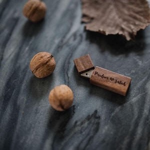 May include: A wooden USB flash drive with a sliding cover. The drive is engraved with the text "Paulina & Jakob" and a heart symbol.