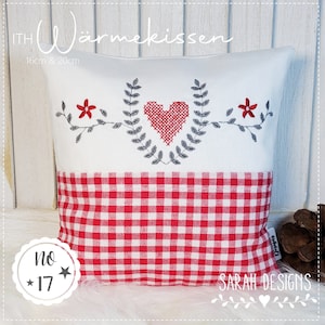Può includere: Un cuscino bianco con un motivo a quadri rossi e bianchi sulla metà inferiore. La metà superiore presenta un cuore ricamato grigio con foglie e fiori rossi su entrambi i lati. Il cuscino è etichettato "ITH WärmeKissen 16cm & 20cm" e "No. 17" con una stella su entrambi i lati. L'angolo inferiore destro del cuscino ha il testo "SARAH DESIGNS" con un piccolo cuore.