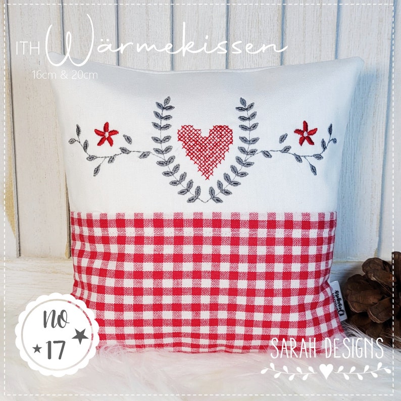 Op de afbeelding: Een wit kussen met een rood-wit geruit patroon op de onderste helft. De bovenste helft heeft een grijs geborduurd hart met bladeren en rode bloemen aan beide kanten. Het kussen is gelabeld "ITH W&auml;rmeKissen 16cm & 20cm" en "No. 17" met een ster aan beide kanten. De rechter benedenhoek van het kussen heeft de tekst "SARAH DESIGNS" met een klein hart.