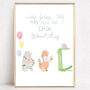May include: Watercolor print with a gold frame featuring a rhino, bear, and crocodile playing instruments and a birthday cake. The text reads "Lebe jeden Tag als sei es Dein Geburtstag" in light blue script, with colorful balloons.