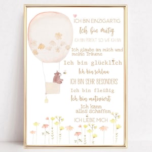May include: A framed print featuring a watercolor illustration of a hot air balloon with a bear in the basket. The balloon is peach-colored with floral accents. The print includes text in German, with a floral border at the bottom.
