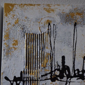 K&ouml;nnte beinhalten: Abstrakte Kunstmalerei auf Leinwand mit goldener, schwarzer und wei&szlig;er Farbe. Das Gem&auml;lde hat eine strukturierte Oberfl&auml;che und einen modernen Stil.