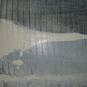 May include: A close-up of a textured, gray surface with a white, abstract shape. The surface has a subtle, vertical pattern.