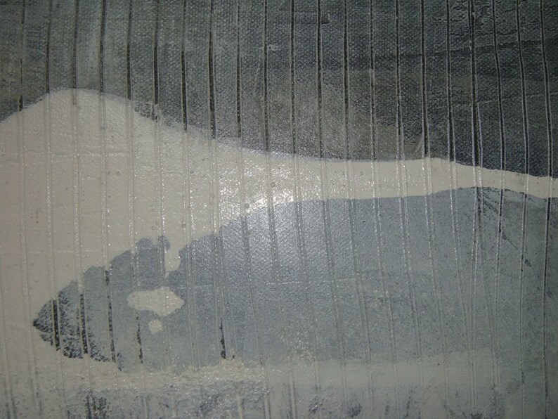 May include: A close-up of a textured, gray surface with a white, abstract shape. The surface has a subtle, vertical pattern.