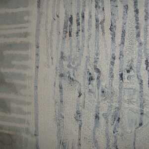 May include: A close-up of a textured wall with vertical lines of white paint and dark gray streaks. The wall has a rough, uneven surface.