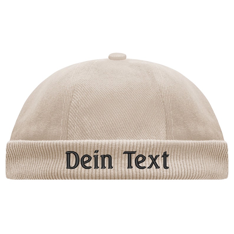 May include: A beige corduroy beanie with a black embroidered text that says "Dein Text".