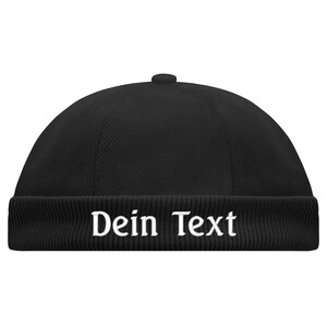 May include: Black beanie with a ribbed cuff and the text "Dein Text" embroidered in white.