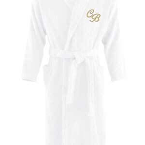 May include: White bathrobe with a long sleeve and a belt. The robe has a gold embroidered monogram "CB" on the left chest.