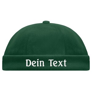 May include: A dark green beanie with a folded brim and the text "Dein Text" embroidered in white.