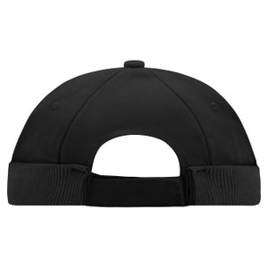 May include: Black beanie style cap with a folded brim. The cap is made of a soft, stretchy fabric.