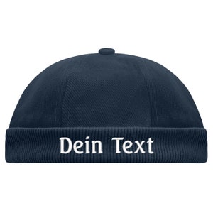 May include: A navy blue corduroy beanie with a white embroidered text that says "Dein Text".