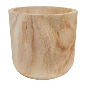 May include: A natural wood planter with a rounded bottom and a smooth, light brown finish. The planter is made from a single piece of wood and has a natural grain pattern.