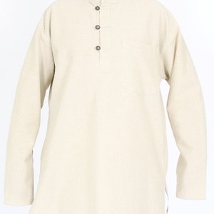 May include: A beige long-sleeved tunic with a mandarin collar and three wooden buttons. The tunic has a single pocket on the chest and a split hem. The collar has a red lining. The tunic is made of a soft, textured fabric.