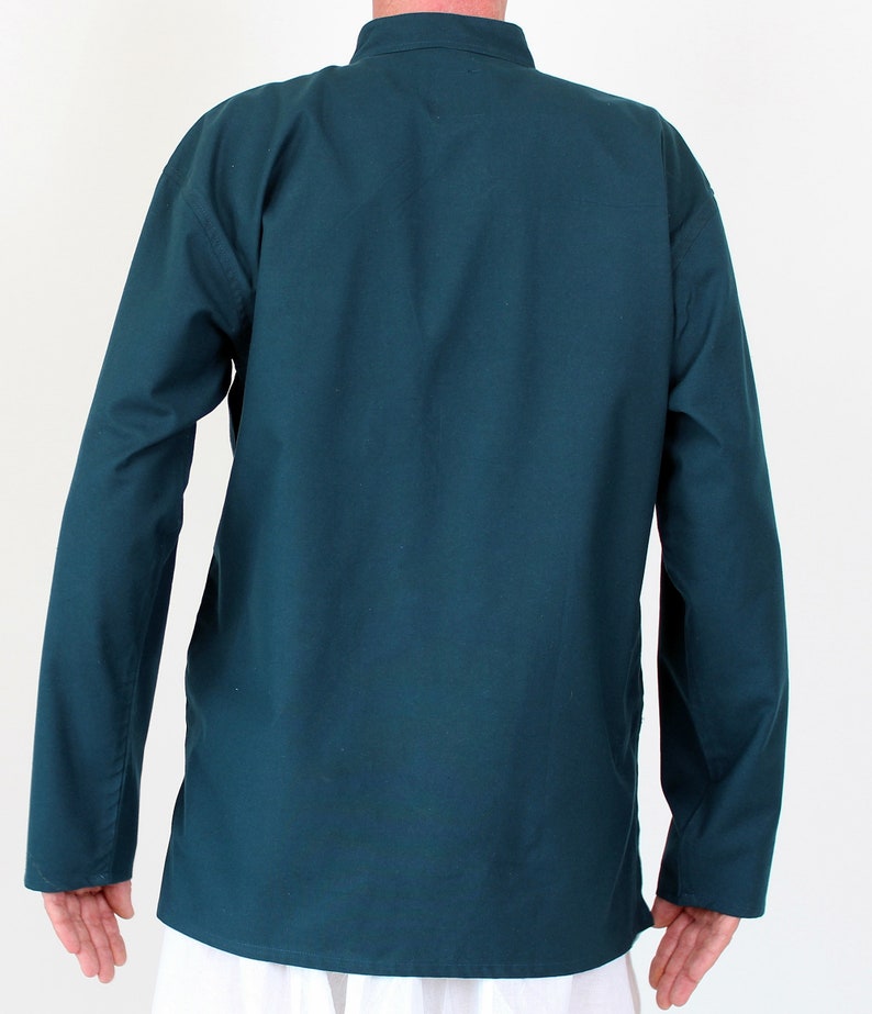 May include: A teal-colored long-sleeve shirt with a mandarin collar. The shirt has a relaxed fit and is made of a solid, opaque fabric. The sleeves are long and end at the wrists. The shirt is a solid color and has a simple, minimalist design.