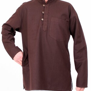 May include: A long-sleeved, dark brown tunic with a mandarin collar and three button closure. The tunic features a single pocket on the chest and side pockets. The garment is made of a solid, plain weave fabric.