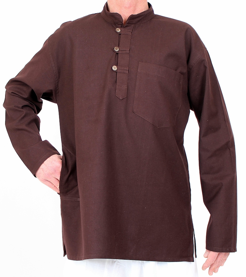 May include: A long-sleeved, dark brown tunic with a mandarin collar and three button closure. The tunic features a single pocket on the chest and side pockets. The garment is made of a solid, plain weave fabric.