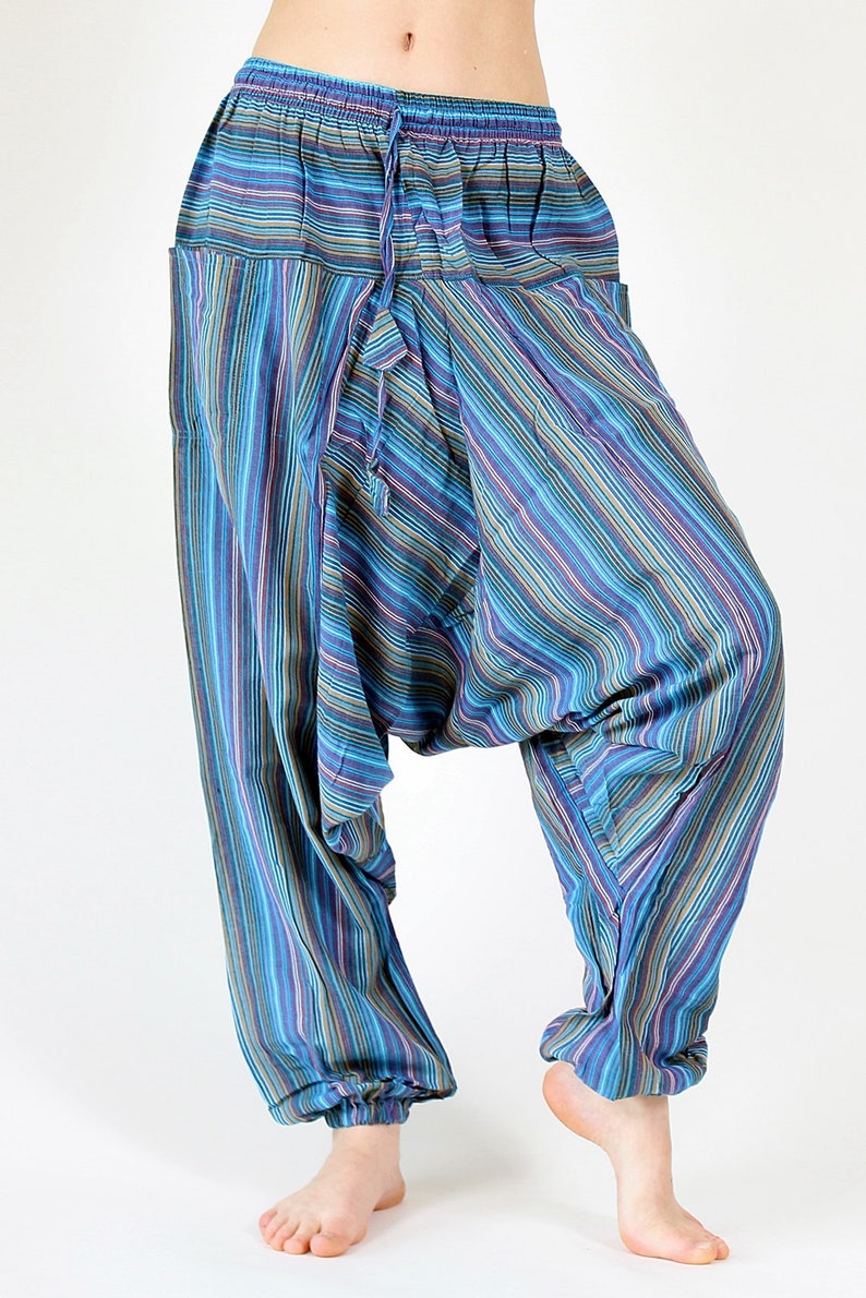 May include: Harem pants with a striped pattern in shades of blue, purple, and green. The pants have a drawstring waist and pockets. The fabric appears lightweight and comfortable.