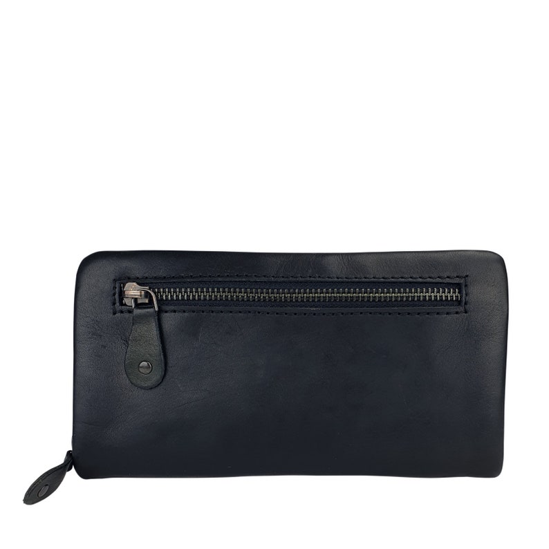 May include: A black leather wallet with a zipper closure. The wallet has a flap with a metal button.