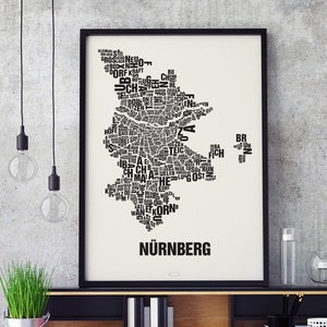 May include: A black and white typography print of the city of Nuremberg, Germany. The print features the city's name in large letters at the bottom and a map of the city made up of smaller words.