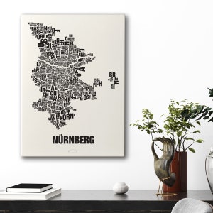 May include: A black and white word art print of the city of Nuremberg, Germany. The print is shaped like the outline of the city and is made up of words related to the city.