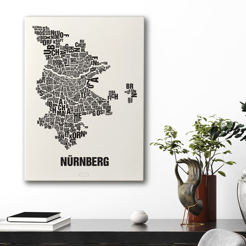 May include: A black and white word art print of the city of Nuremberg, Germany. The print is shaped like the outline of the city and is made up of words related to the city.