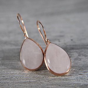 Könnte beinhalten: Ein Paar Ohrringe aus Roségold mit tropfenförmigen rosafarbenen Quarzsteinen.