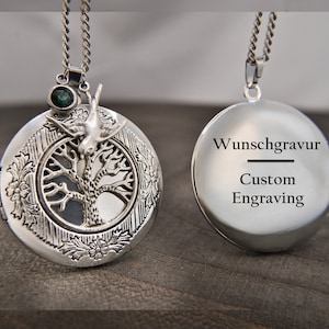 Può includere: Collana con ciondolo in argento con un design ad albero della vita e una piccola pietra preziosa verde. Il retro del ciondolo è vuoto e dice "Wunschgravur Custom Engraving".