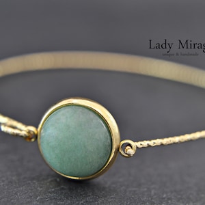 May include: A gold chain bracelet with a green stone cabochon. The bracelet is delicate and features a simple design.  Lady Mirage unique & handmade.