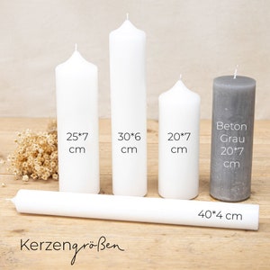 May include: Five white pillar candles of different sizes, with measurements in inches, and one gray pillar candle. The candles are arranged on a wooden surface. The text "Kerzengr&ouml;&szlig;en" is visible at the bottom of the image. The largest candle is 40 inches long and 4 inches wide.
