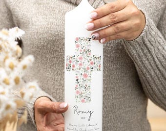 May include: White baptism candle with a floral cross design and the name "Romy" written below. The text "Wenn aus Liebe Leben wird,  bekommt das Glück einen Namen" is written below the name.