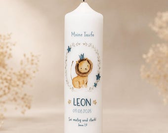May include: A white cylindrical pillar candle with a lit wick, featuring a watercolour illustration of a lion wearing a crown inside a leafy wreath. The text reads "Meine Taufe", "LEON", "09.08.2026", "Sei mutig und stark!", and "Josua 1,9".