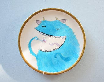 Wall plate gold rim hand-painted with a blue monster - cake