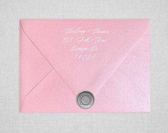 May include: A pink envelope with a silver wax seal featuring the letter "W". The envelope is addressed to Sterling Stripes, 123 Ash Ave, Omega, OR 74034.