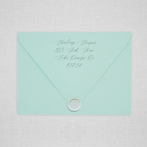 May include: A light blue envelope with a white wax seal. The address is written in cursive: Sterling Stripes, 123 Ash Ave, Lake Oswego, OR 97034.