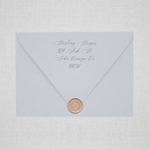 May include: A light blue envelope with a wax seal. The envelope has an address written on it: Sterling Stripes, 524 Ash St, Lake Oswego, OR 97034.