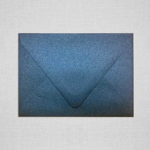 May include: A dark blue envelope with a subtle textured finish.