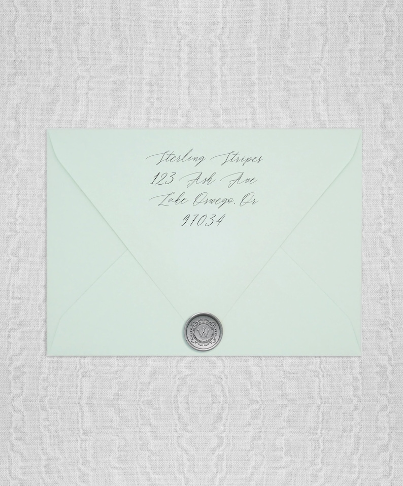 May include: A light blue envelope with a silver wax seal. The address is written in cursive: Sterling Stripes, 123 Ash Ave, Lake Oswego, OR 97034.